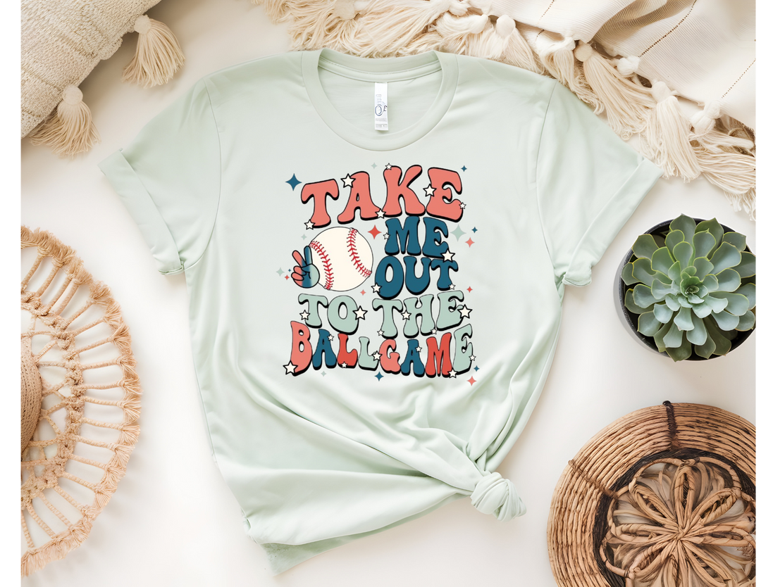 A flat lay of a cream t-shirt with a floral heart design, denim shorts, a plaid shirt, and a brown hat