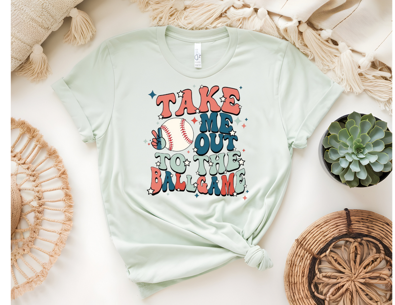 A flat lay of a cream t-shirt with a floral heart design, denim shorts, a plaid shirt, and a brown hat